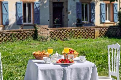 Salle spacieuse avec carrelage au sol, grandes baies vitrées, poutres apparentes et lustres suspendus.