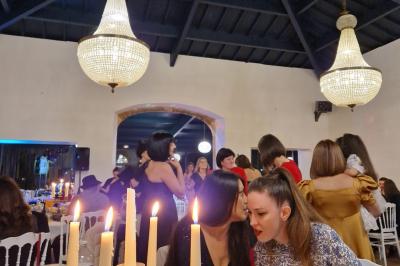 Salle spacieuse avec carrelage au sol, grandes baies vitrées, poutres apparentes et lustres suspendus.