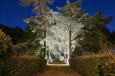 Salle spacieuse avec carrelage au sol, grandes baies vitrées, poutres apparentes et lustres suspendus.