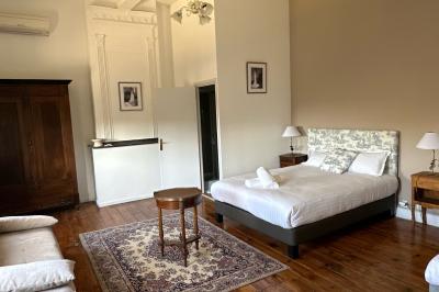 Salle spacieuse avec carrelage au sol, grandes baies vitrées, poutres apparentes et lustres suspendus.