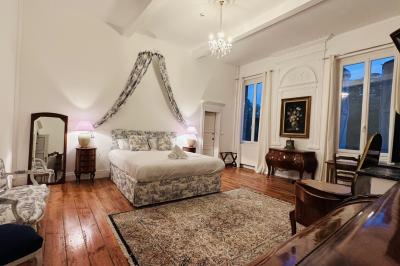 Salle spacieuse avec carrelage au sol, grandes baies vitrées, poutres apparentes et lustres suspendus.