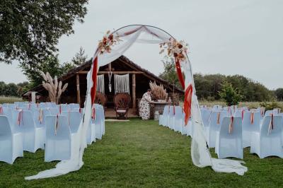 Salle décorée avec des fûts recyclés en tables, éclairage chaleureux et éléments rustiques en bois.