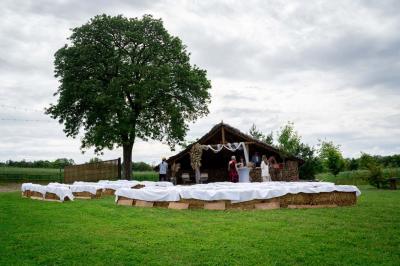 Salle décorée avec des fûts recyclés en tables, éclairage chaleureux et éléments rustiques en bois.