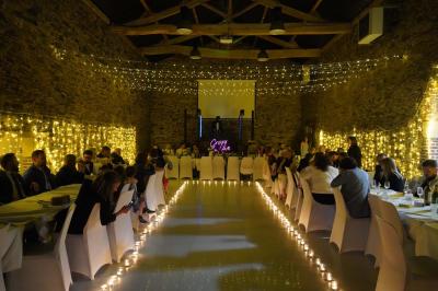 Salle décorée avec des fûts recyclés en tables, éclairage chaleureux et éléments rustiques en bois.