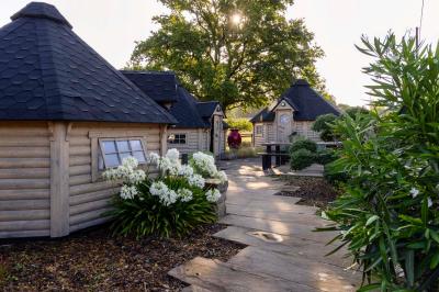 Salle décorée avec des fûts recyclés en tables, éclairage chaleureux et éléments rustiques en bois.