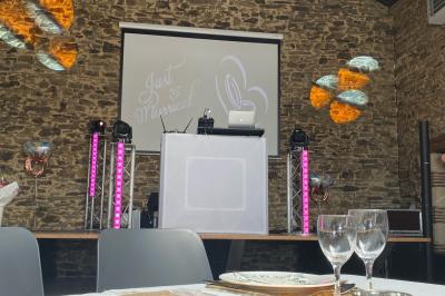 Salle décorée avec des fûts recyclés en tables, éclairage chaleureux et éléments rustiques en bois.