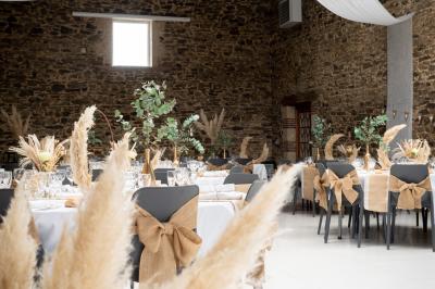 Salle décorée avec des fûts recyclés en tables, éclairage chaleureux et éléments rustiques en bois.