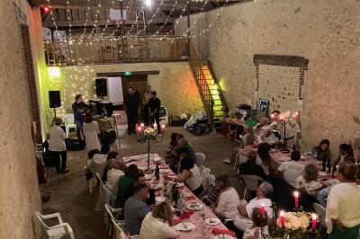 Salon rustique avec murs en pierre, canapés en cuir, table basse et porte ouverte donnant sur un jardin ensoleillé.