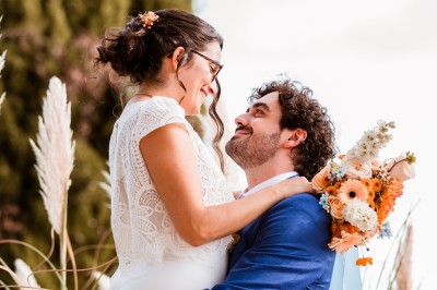 Deux mains tendues l'une vers l'autre au-dessus d'un champ de tournesols fanés.