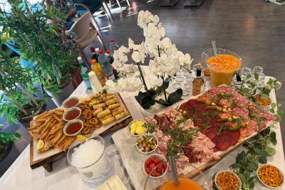 Buffet avec verrines, brochettes de fruits, amuse-bouches et coupes de vin sur une table en bois.