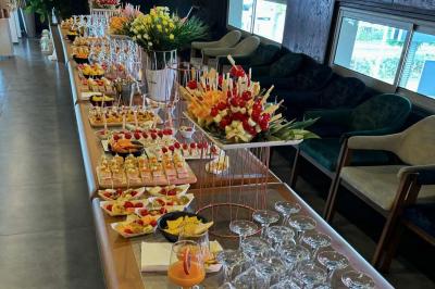 Buffet avec verrines, brochettes de fruits, amuse-bouches et coupes de vin sur une table en bois.