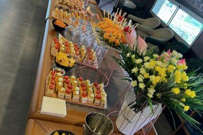 Buffet avec verrines, brochettes de fruits, amuse-bouches et coupes de vin sur une table en bois.