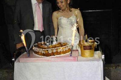 Miniature Location salle Neuilly-en-Thelle (Oise) - Château du Corps de Garde #21 Gâteau de mariage blanc décoré de roses bleues et blanches, avec des figurines humoristiques en haut.