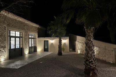 Entrée avec porte vitrée, mur végétal à droite, sol en béton et éclairage au sol.