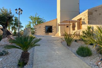 Entrée avec porte vitrée, mur végétal à droite, sol en béton et éclairage au sol.