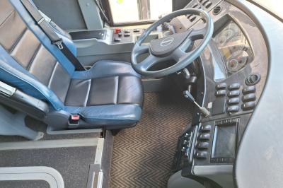 Intérieur d'un véhicule spacieux avec sièges en cuir noir, toit ouvrant et fenêtres équipées de rideaux.