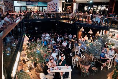 À gauche, des boules de pétanque sur un terrain sablonneux ; à droite, une façade de gare ensoleillée avec une horloge.