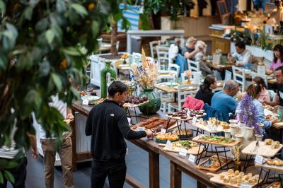 À gauche, des boules de pétanque sur un terrain sablonneux ; à droite, une façade de gare ensoleillée avec une horloge.