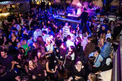 À gauche, des boules de pétanque sur un terrain sablonneux ; à droite, une façade de gare ensoleillée avec une horloge.