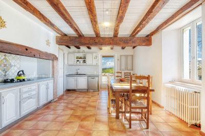 Petite voiture ancienne bleue avec toit ouvert, stationnée sur une pelouse près d'arbres et d'un bâtiment en arrière-plan.