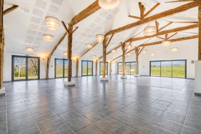 Petite voiture ancienne bleue avec toit ouvert, stationnée sur une pelouse près d'arbres et d'un bâtiment en arrière-plan.