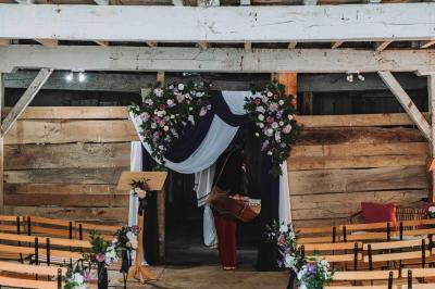 Petite voiture ancienne bleue avec toit ouvert, stationnée sur une pelouse près d'arbres et d'un bâtiment en arrière-plan.