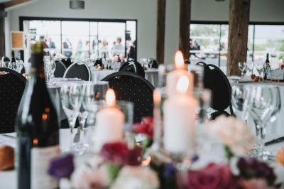 Petite voiture ancienne bleue avec toit ouvert, stationnée sur une pelouse près d'arbres et d'un bâtiment en arrière-plan.