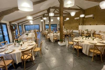 Petite voiture ancienne bleue avec toit ouvert, stationnée sur une pelouse près d'arbres et d'un bâtiment en arrière-plan.