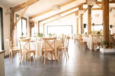 Petite voiture ancienne bleue avec toit ouvert, stationnée sur une pelouse près d'arbres et d'un bâtiment en arrière-plan.