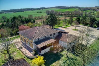 Un groupe de personnes participe à une réunion dans une salle avec des murs en pierre et une charpente apparente.