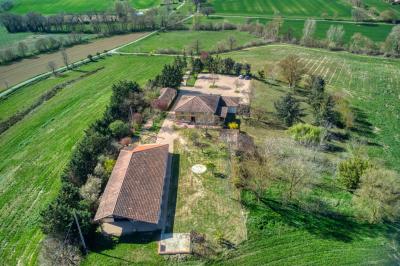 Un groupe de personnes participe à une réunion dans une salle avec des murs en pierre et une charpente apparente.