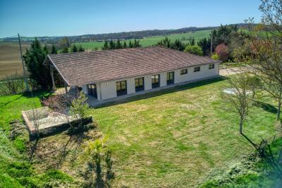 Un groupe de personnes participe à une réunion dans une salle avec des murs en pierre et une charpente apparente.