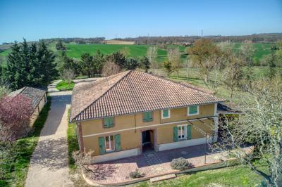 Un groupe de personnes participe à une réunion dans une salle avec des murs en pierre et une charpente apparente.