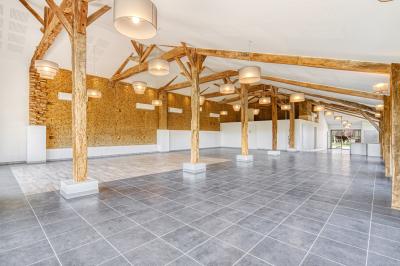 Un groupe de personnes participe à une réunion dans une salle avec des murs en pierre et une charpente apparente.