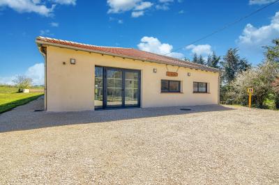 Un groupe de personnes participe à une réunion dans une salle avec des murs en pierre et une charpente apparente.