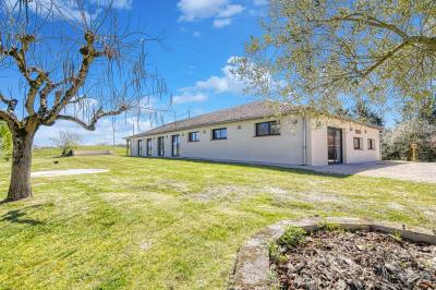 Un groupe de personnes participe à une réunion dans une salle avec des murs en pierre et une charpente apparente.