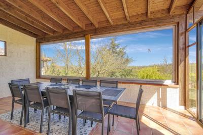 Un groupe de personnes participe à une réunion dans une salle avec des murs en pierre et une charpente apparente.