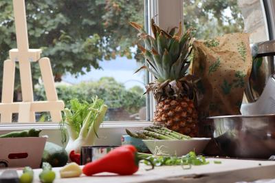 Verrines de fromage frais garnies de figues, noix, feuilles de menthe et cuillères en bois sur un plateau blanc.