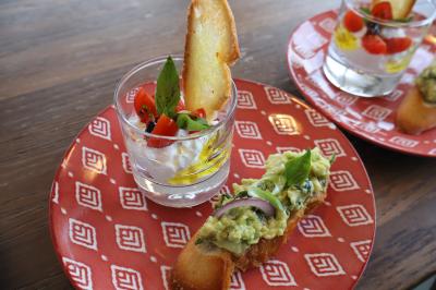 Verrines de fromage frais garnies de figues, noix, feuilles de menthe et cuillères en bois sur un plateau blanc.