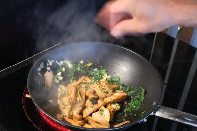 Verrines de fromage frais garnies de figues, noix, feuilles de menthe et cuillères en bois sur un plateau blanc.