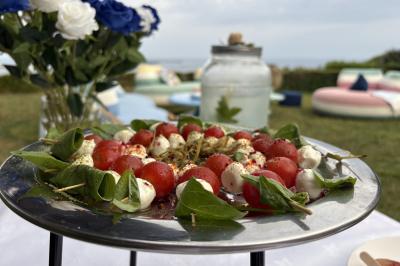 Verrines de fromage frais garnies de figues, noix, feuilles de menthe et cuillères en bois sur un plateau blanc.