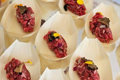 Verrines de fromage frais garnies de figues, noix, feuilles de menthe et cuillères en bois sur un plateau blanc.