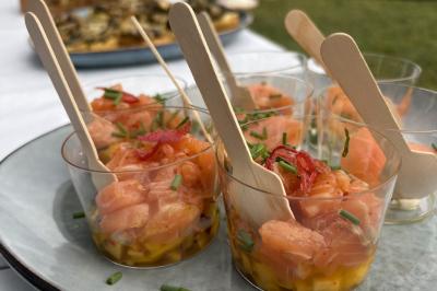 Verrines de fromage frais garnies de figues, noix, feuilles de menthe et cuillères en bois sur un plateau blanc.