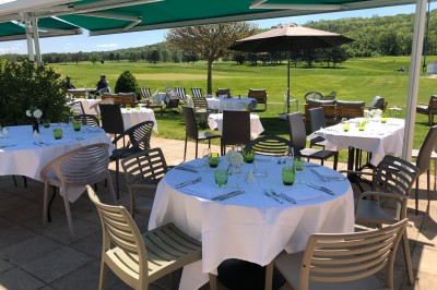 Miniature Location salle Pulnoy (Meurthe-et-Moselle) - Restaurant du Golf de Pulnoy #1 Salle de réception lumineuse avec des tables rondes dressées pour un événement, entourées de chaises blanches.