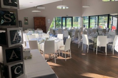 Miniature Location salle Pulnoy (Meurthe-et-Moselle) - Restaurant du Golf de Pulnoy #6 Salle de réception lumineuse avec des tables rondes dressées pour un événement, entourées de chaises blanches.