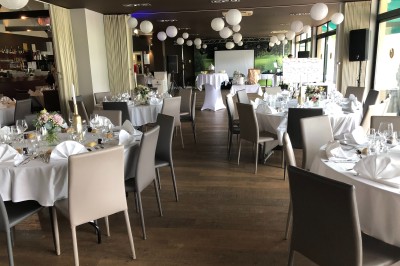 Miniature Location salle Pulnoy (Meurthe-et-Moselle) - Restaurant du Golf de Pulnoy #2 Salle de réception lumineuse avec des tables rondes dressées pour un événement, entourées de chaises blanches.