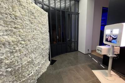 Un groupe de mannequins en tenues élégantes défile sur une scène, observé par un public dans une salle lumineuse.