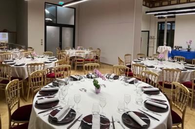 Un groupe de mannequins en tenues élégantes défile sur une scène, observé par un public dans une salle lumineuse.