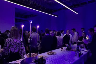 Vue intérieure d'une pièce lumineuse avec de grandes baies vitrées donnant sur un jardin et des bâtiments voisins.