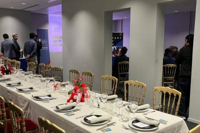 Vue intérieure d'une pièce lumineuse avec de grandes baies vitrées donnant sur un jardin et des bâtiments voisins.